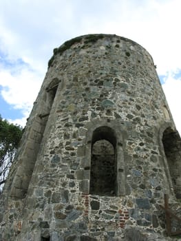 The castle keep stands tall against a blue sky with clouds.