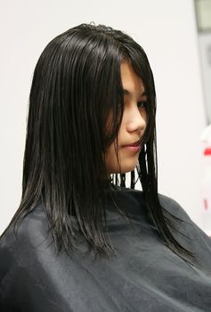 Young teen girl getting haircut