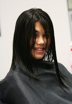 Young teen girl getting haircut