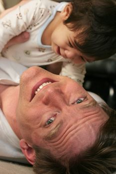 Father playing with baby boy  on floor