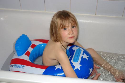 The girl, floats in pool with a life buoy