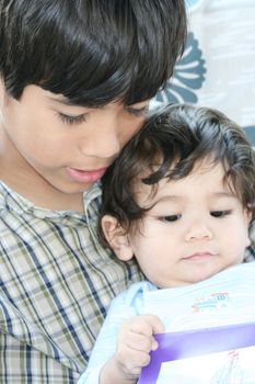 Big brother reading to baby brother