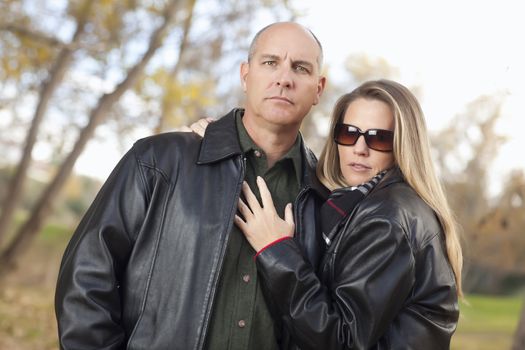 Serious Attractive Couple in Park with Leather Jackets.