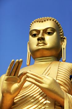The giant golden Buddha statue sitting on the roof of the Golden Temple in Dambulla, Sri Lanka. Built in 2001 it is said to be the largest of its kind in the world.