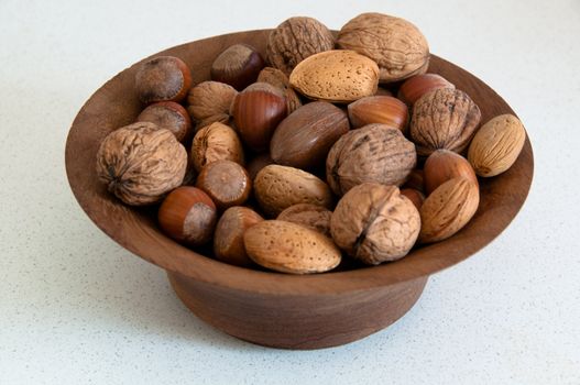 assortment of several kind of nuts in a wooden bowl