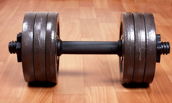 Single heavy dumbbell on a floor