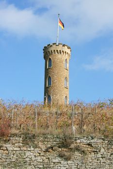 Turm im Weinberg mit Deutscher Flagge,und blauem himmel im Hintergrund	
Tower in the vineyard with the German flag and a blue sky in the background
