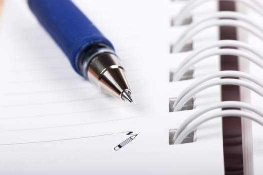 Macro view of blank spiral notebook and pen