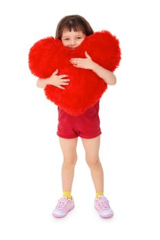 Little girl hugging a toy heart, isolated on a white background
