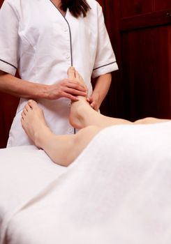 A masseur giving a professional foot massage in an old style spa