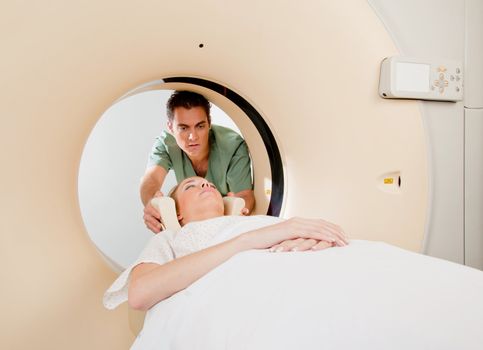 A CT scan technician aligning a patient in the machine