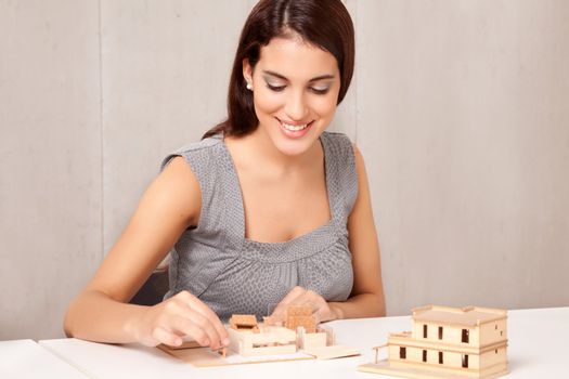 A female interior designer working on a scale model