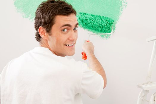 Portrait of a male doing home improvements, paiting a wall