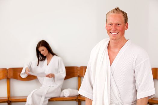 Portrait of a man at a spa with a woman in the background