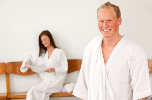 Portrait of a happy man in a bathrobe in a spa reception area