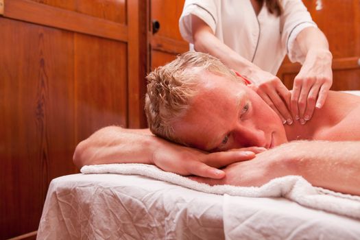 Detail of a man receiving a shoulder massage in an old 1920's styled spa