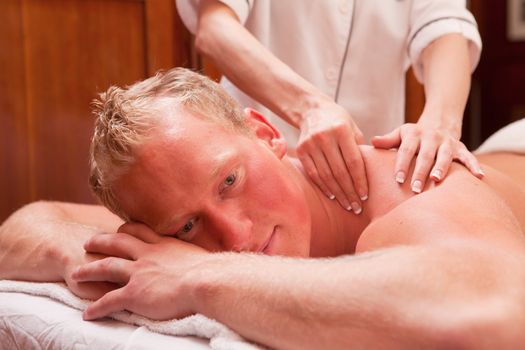 A detail of a man receiving a back and shoulder massage in an old style spa