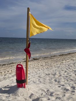 Lifeguard flotation device and warning flag on the beach