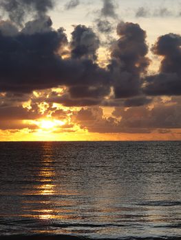 Sunrise on the ocean, during a cloudy day