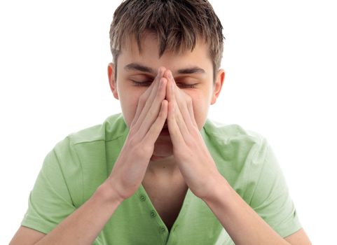 A teen boy sits with head buried in pyramid hands, showing stress, pain, or deep in thought, 