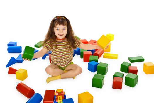 Little girl playing with colored cubes on the floor isolated on white background