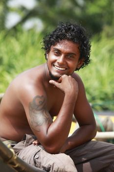 The young man sitting by a boat. Sri Lanka