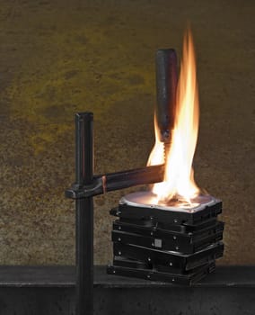 flames on stack of pressed hard drives. pressed by clamp