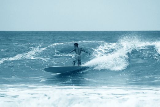 Young men - the surfer in ocean. Bali. Indonesia