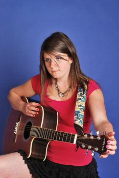 pretty girl in skirt playing on guitar