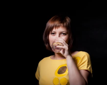 young woman with glass water, black background