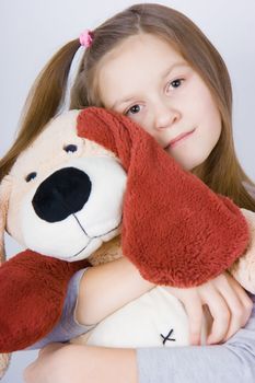 sad girl hugging a toy dog. Portrait of a close-up
