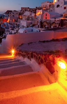 Stairway path towards the beautiful village of Oia, illuminated at dusk