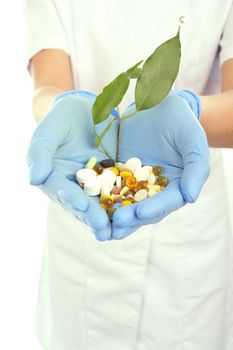 young doctor holding pills and a plant 