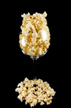 Picture of a wine glass with popcorn in and outside