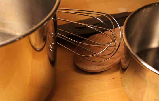 Various cooking tools sitting on a wooden table.