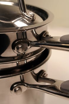 A close up of a stack of stainless steel pots.