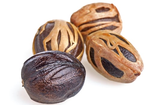 some whole nutmegs on white background