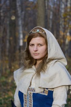 Portrait of the romantic girl in autumn forest
