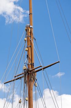 Wooden mast of a sailboat against the sky