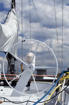 Detail of rudder and equipment on a sailboat against a cloudy sky