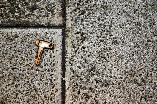 Rusted key on sidewalk with copy space