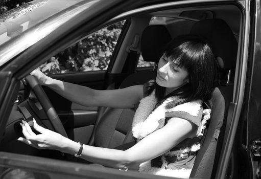 Beautiful brunette in the automobile. b/w