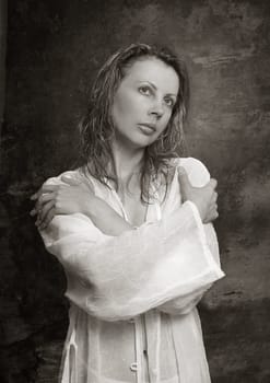 The portrait of the thoughtful girl, hands are crossed on a breast. b/w+sepia