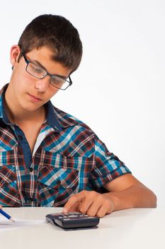 Teenager working with his calculator on maths exercises