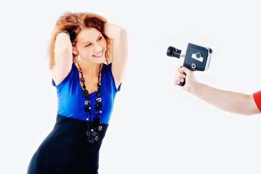 Young woman posing in front of old video camera