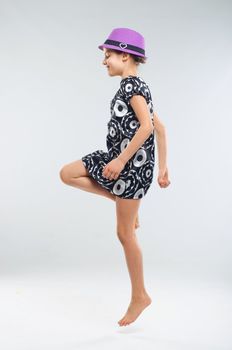 Pretty girl in a beautiful dress and a hat in the studio