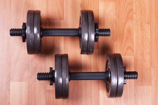 Two heavy dumbbells on a floor