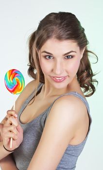Portrait of smiling teenager girl holding colorful lollipop