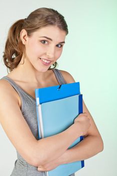 Pretty teenager girl holding blue plastic folders