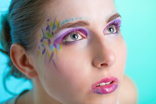 Closeup portrait of a pretty young woman with face art